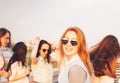 Positive beautiful happy red haired girl in the mirror sunglasses with friends on blue sky background, summer sunset time Royalty Free Stock Photo