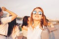 Positive beautiful happy red haired girl in the mirror sunglasses with friends on blue sky background, summer sunset time Royalty Free Stock Photo