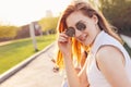 Positive beautiful happy red haired girl in mirror sunglasses with friends on city street background, summer sunset time Royalty Free Stock Photo