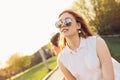 Positive beautiful happy red haired girl in mirror sunglasses with friends on city street background, summer sunset time Royalty Free Stock Photo