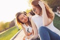 Positive beautiful happy red haired girl in mirror sunglasses with friends on city street background, summer sunset time Royalty Free Stock Photo