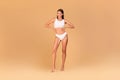 Positive beautiful lady posing in white underwear bra and panties, holding hands on her waist, demonstrating nice curves Royalty Free Stock Photo