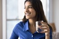 Positive beautiful 20s Indian girl holding glass of clear water Royalty Free Stock Photo