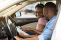 Positive black couple having car trip, checking map