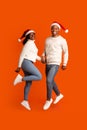 Positive Black Couple Wearing Santa Hats Jumping And Having Fun Together Royalty Free Stock Photo