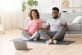 Positive black expecting couple having online yoga class