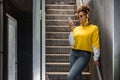 Positive black hipster woman in trendy outfit using mobile phone