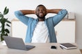 Positive Black Male Freelancer Leaning Back In Chair, Resting At Workplace Royalty Free Stock Photo