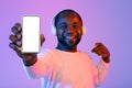 Positive black man pointing at cell phone with white screen Royalty Free Stock Photo