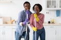 Positive black man and woman cleaning house and having fun Royalty Free Stock Photo