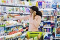 Positive black woman making phone call while shopping for personal care products at beauty department of mall Royalty Free Stock Photo