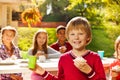 Positive blond boy with his friends sitting Royalty Free Stock Photo