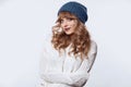 Positive blond woman in sweater and hat on white background Royalty Free Stock Photo