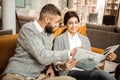 Positive bright couple deciding on equipment of future apartments