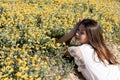 Positive brunette woman lying on yellow flowers on lawn,stock image Royalty Free Stock Photo