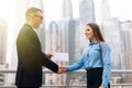Positive business partners finishing meeting with handshake. Business man and woman shaking hands outdoors. Dealing or partnership Royalty Free Stock Photo