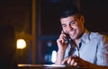 Businessman Having Pleasant Phone Conversation Sitting In Office At Night Royalty Free Stock Photo