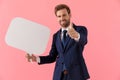 Positive businessman holding a speech bubble an gesturing ok Royalty Free Stock Photo