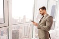 Positive businessman standing in the office near window Royalty Free Stock Photo