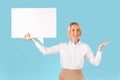 Positive businesswoman holding speech bubble over blue studio background, space for design, panorama Royalty Free Stock Photo