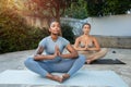 Positive calm millennial black and arab women do breathing exercises in lotus position, meditation, practice yoga Royalty Free Stock Photo