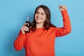 Positive carefree young woman starting energetic dance after drinking fizzy water having fun relaxing on party posing isolated