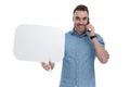 Positive casual holding blank speech bubble, smiling, talking on phone Royalty Free Stock Photo