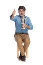 Positive casual man holding a trophy and giving thumbs up Royalty Free Stock Photo