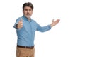 Positive casual man presenting and giving a thumbs up Royalty Free Stock Photo