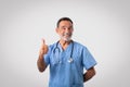 Positive caucasian mature doctor in uniform show thumb up, recommend medicine service Royalty Free Stock Photo