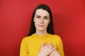 Positive cheerful woman with lovely sincere smile feeling thankful and grateful, showing her heart filled with love Royalty Free Stock Photo