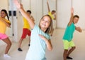 Positive children studying modern style dance in class