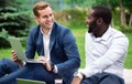 Positive colleagues sitting on the grass Royalty Free Stock Photo