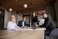 Positive confident business colleagues sitting, standing at meeting table Royalty Free Stock Photo