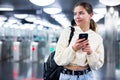 Positive girl with a mobile phone entered the subway, passing through the turnstile Royalty Free Stock Photo