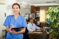 Positive confident young female doctor in a resident's office, writes important notes Royalty Free Stock Photo