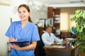 Positive confident young female doctor in a resident's office, writes important notes Royalty Free Stock Photo