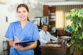 Positive confident young female doctor in a resident's office, writes important notes Royalty Free Stock Photo