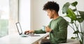 Positive cool african american guy using laptop at cafe Royalty Free Stock Photo