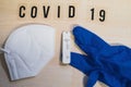 A positive corona rapid test lies next to a medical face mask and a blue medical glove