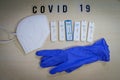 Six positive corona rapid tests lie next to a medical face mask and a blue medical glove Royalty Free Stock Photo