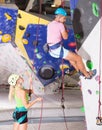 Couple of alpinist practicing in pair indoor rock-climbing Royalty Free Stock Photo