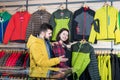 Positive couple deciding on windcheater in store Royalty Free Stock Photo