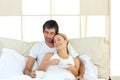 Positive couple drinking coffee lying in the bed Royalty Free Stock Photo