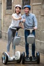 Positive couple going sightseeing by segways