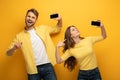 Positive couple showing smartphones with blank screens