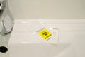 positive covid antigen test in bathroom with a biohazard disposal bag