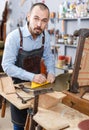 Craftsman reupholstering chair in workshop