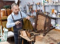 Craftsman reupholstering chair in workshop