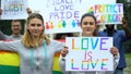Positive crowd raising rainbow symbols and posters for LGBT rights, pride march